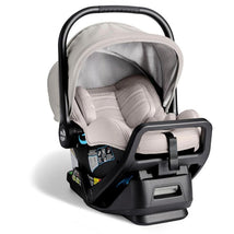 Baby Jogger City Go 2 Infant Car Seat in Frosted Ivory, featuring a padded seat, adjustable handle, and safety labels.