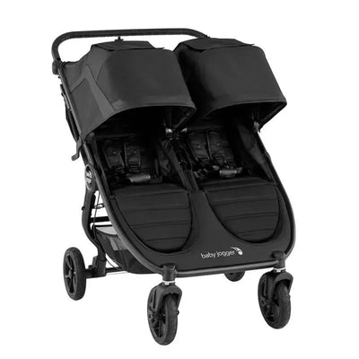 Double stroller in jet black featuring two seats with adjustable canopies and safety harnesses, designed for infants and toddlers.