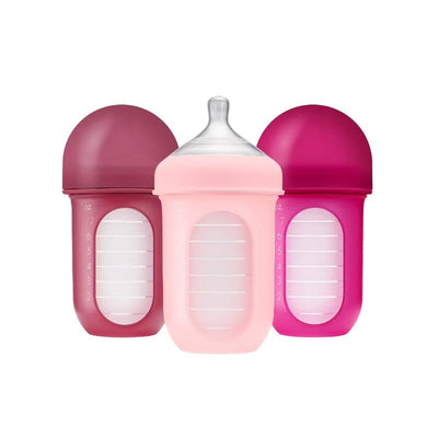 Boon Nursh 8oz baby bottles in pink and purple tones, featuring a silicone sleeve and clear measurement markings.
