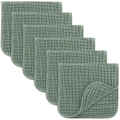 Six soft, fern-colored muslin burp cloths arranged in a stack, showcasing their textured and quilted design.
