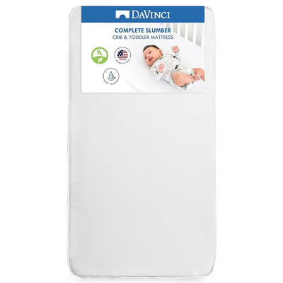 Complete Slumber Crib & Toddler Mattress by DaVinci, featuring a baby on a white mattress with care instructions visible.
