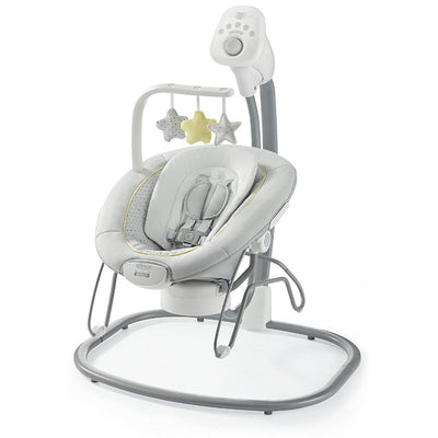 Portable baby swing and bouncer seat in gray and white, featuring toys, music controls, and a secure harness.