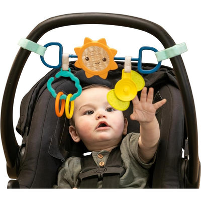 Infantino Sensory Travel Bar with colorful toys; a baby reaching out to play while secured in a car seat.
