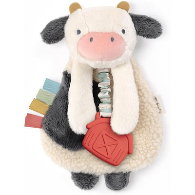 Cow Itzy Friends Lovey™ Plush featuring soft textures, a pink snout, and a red barn-shaped toy attached with tags.