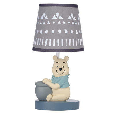 Gray lamp featuring a smiling Winnie the Pooh character with a honey pot, topped with a geometric patterned shade.