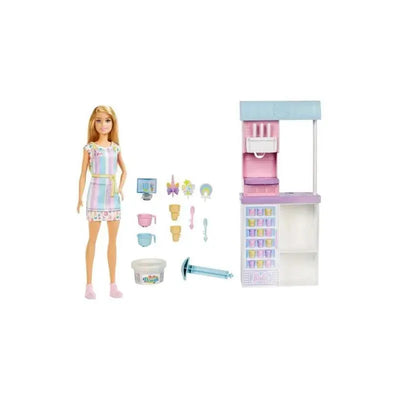 Barbie doll in a colorful dress beside an ice cream shop playset with various accessories, including cones and a scoop.