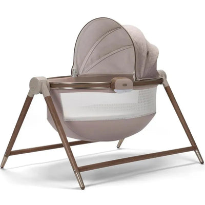 Maxi-Cosi Sibia Bassinet from the Kindred Collection, featuring a natural heritage design, with a curved shape and wooden legs.