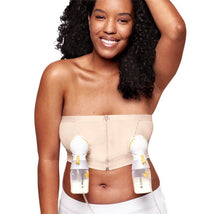 Medela Hands Free Pumping Bustier in chai, worn by a smiling woman, features pumping attachments for breast milk collection.