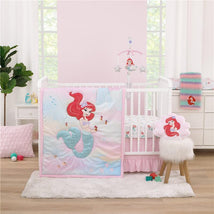 NoJo 3Pk Disney Ariel Watercolor Wishes Crib Bedding Set with pink mermaid-themed blanket and accessories in a nursery setting.