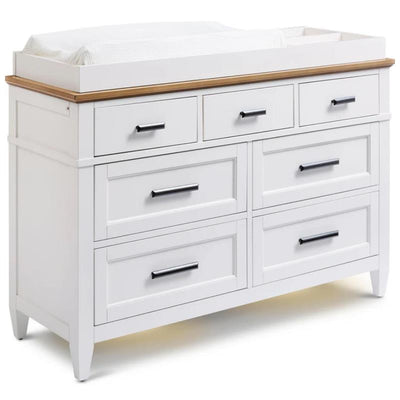 White changing tray dresser with eight drawers, a wooden top, and a cushioned changing pad on the back.