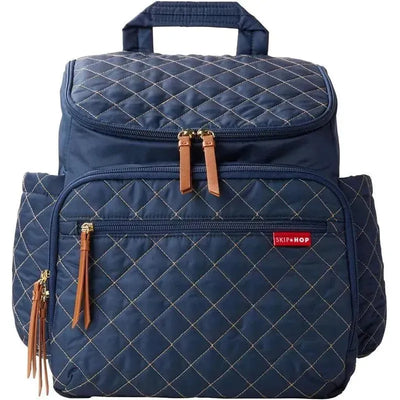 Navy quilted diaper bag backpack by Skip Hop featuring dual zippers, tan leather accents, and multiple pockets.