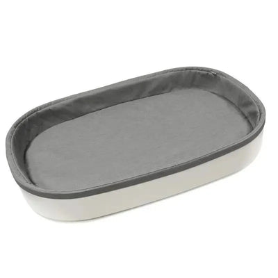 Stokke Sleepi Changer in white with a soft gray padded interior, designed for comfortable diaper changing.