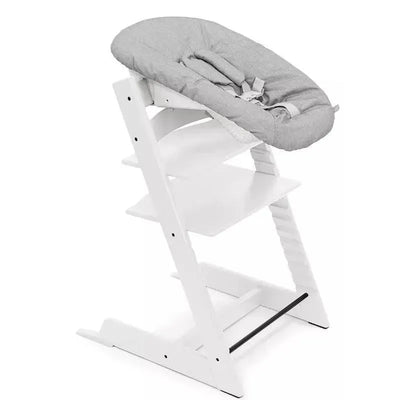 Tripp Trapp high chair bundle in white with a padded gray seat, designed for baby seating at family meals.
