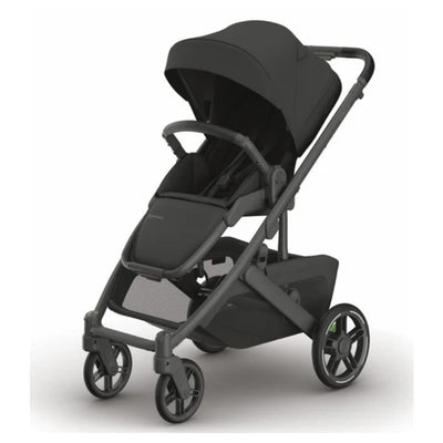 Uppababy Cruz V3 stroller in charcoal with a carbon frame and black leather seat, featuring a canopy and accessible storage.