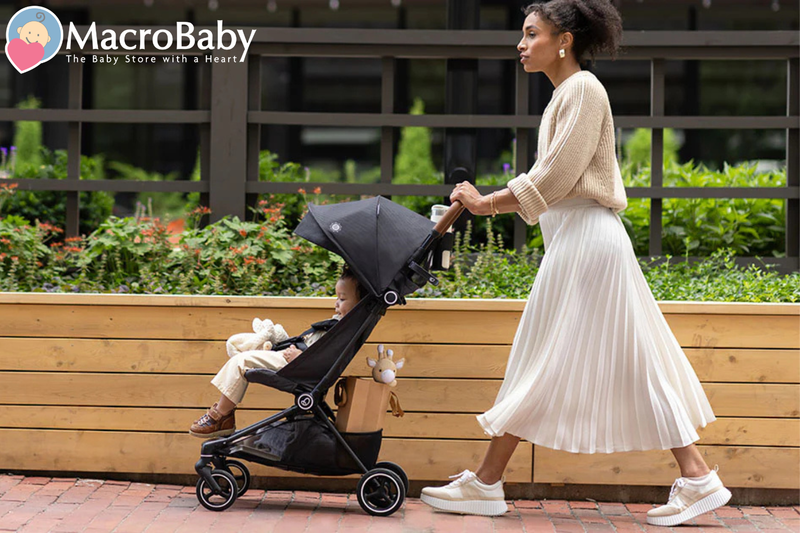 Mom pushing baby in lightweight stroller outdoors, perfect for urban walks and daily errands with comfort and style.