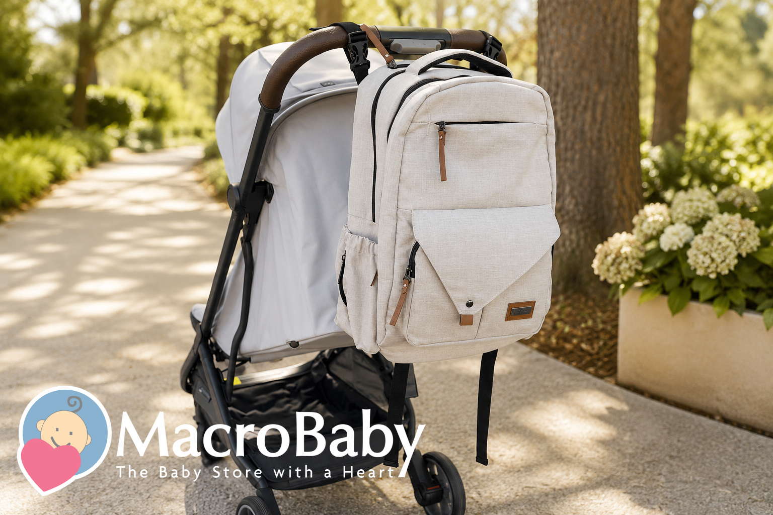 Beige diaper backpack attached to a modern baby stroller in a sunlit park.