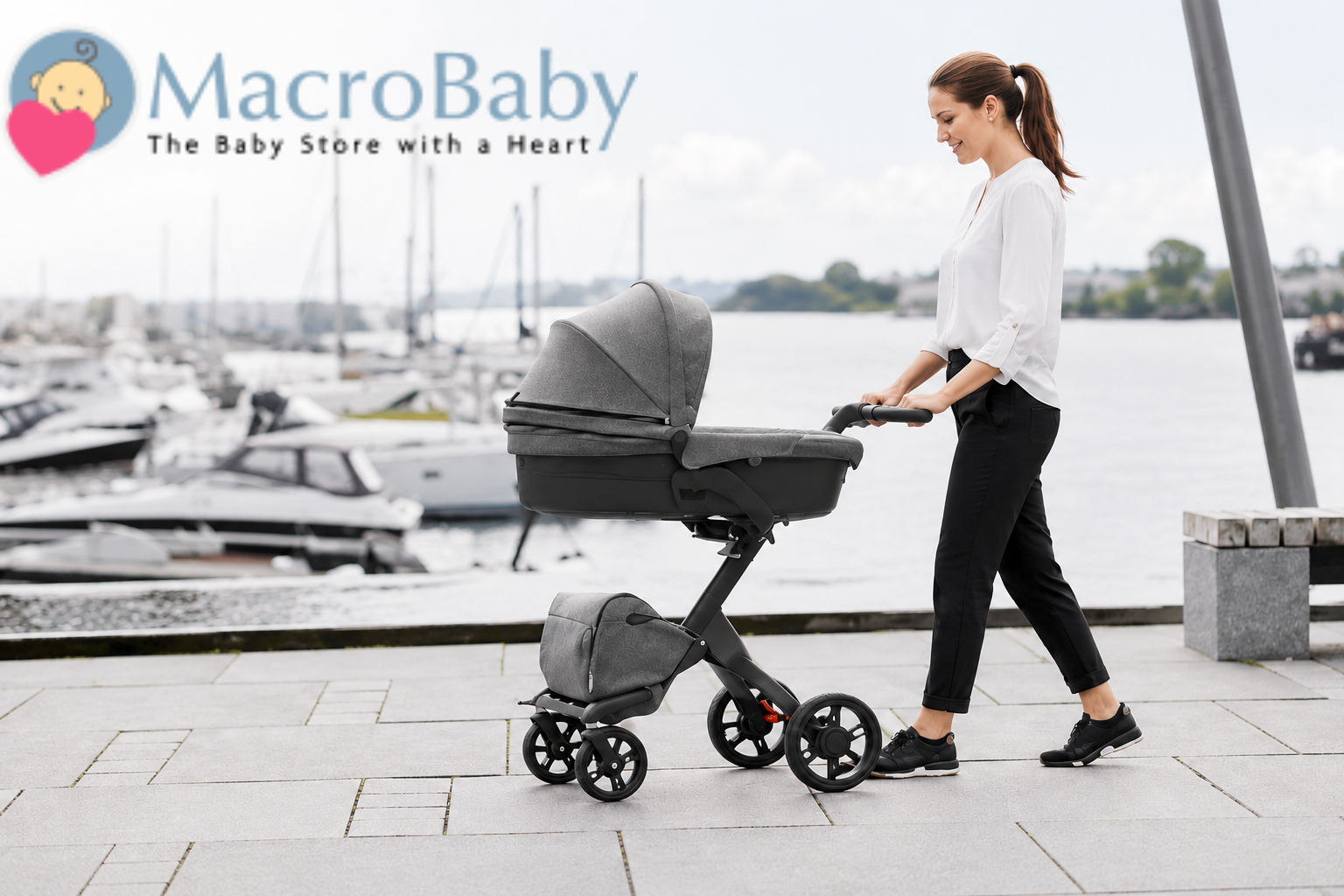 Woman pushing modern baby stroller near waterfront with boats in background