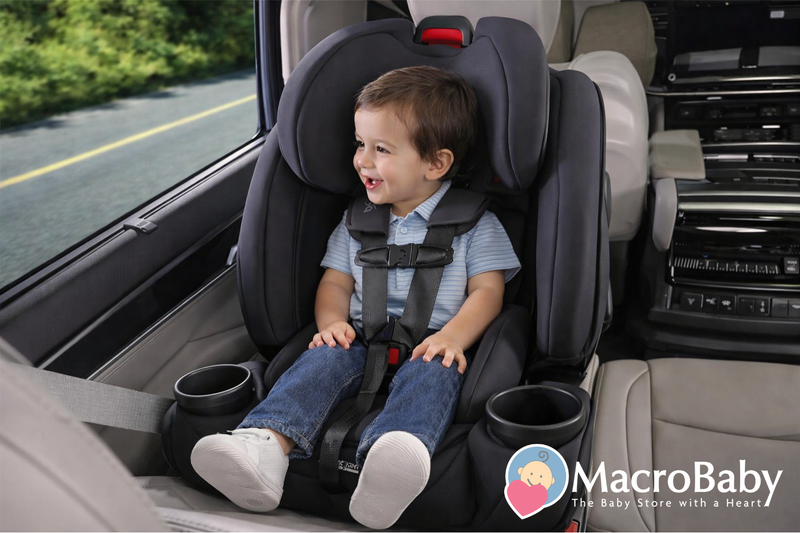 Happy toddler in black car seat with cup holders, safely buckled in vehicle for travel