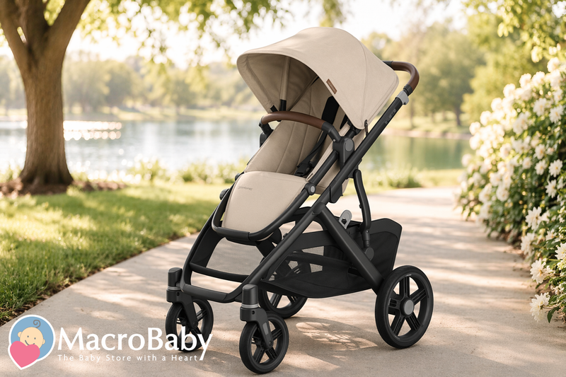 Beige baby stroller with black frame on park path near lake, ideal for moms and babies