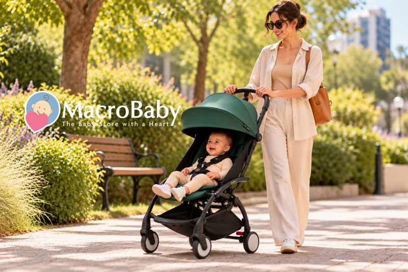 Woman wearing sunglasses strolling with a smiling baby in a green YOYO stroller through a sunny, tree-lined park.