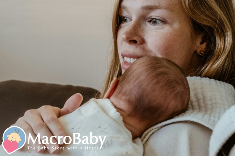 Mother holding her sleeping newborn close, MacroBaby registry essentials blog banner