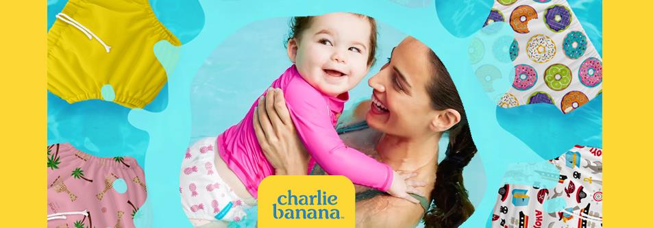 Mom holding baby in pink swimwear, surrounded by colorful Charlie Banana swim diapers and suits