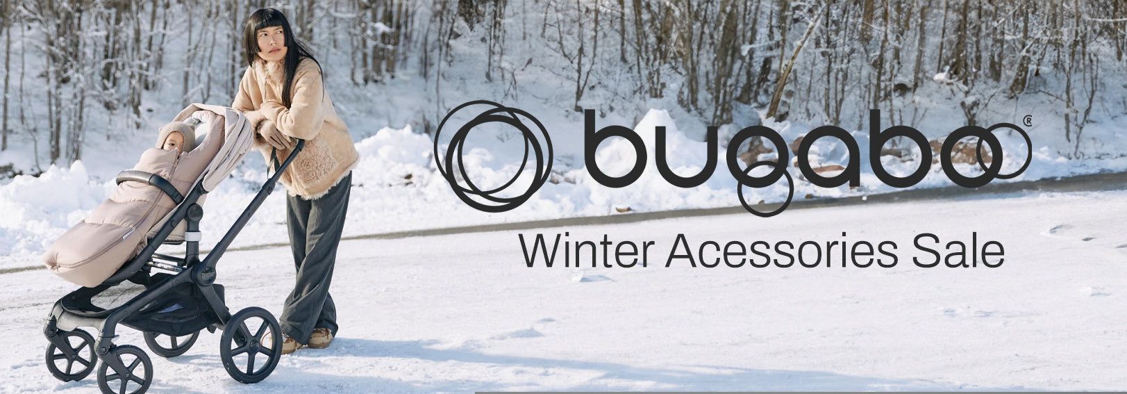 Mom pushing baby stroller with winter accessories in snowy forest, Bugaboo Winter Sale