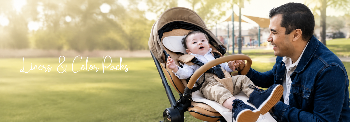 Dad smiling with baby in stylish stroller at park, featuring liners & color packs for baby gear