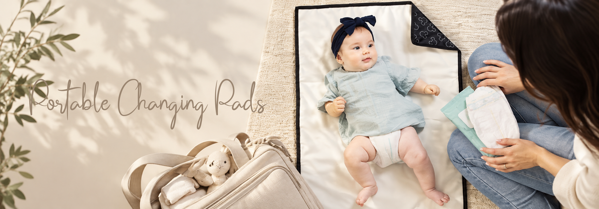 Baby on a portable changing pad with mom nearby.