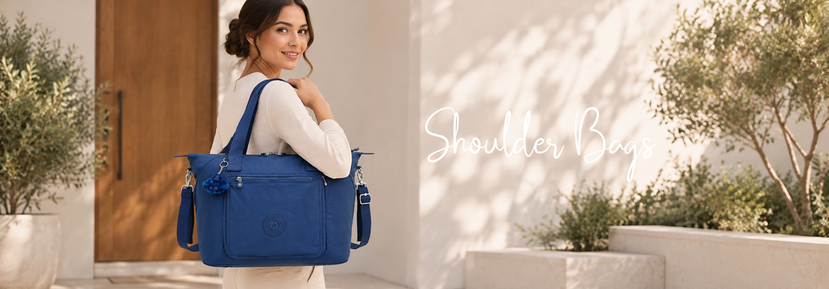 Woman carrying a blue shoulder bag in a modern outdoor setting.