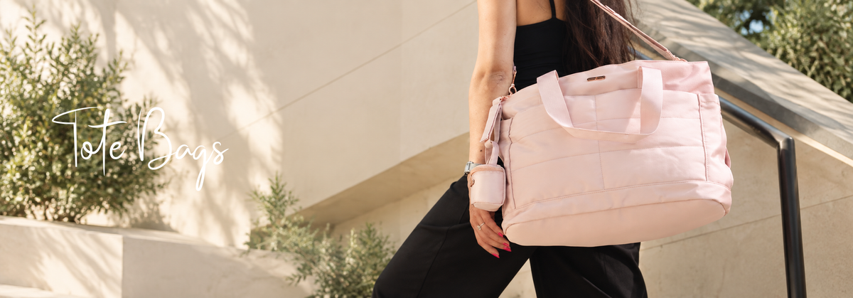 Woman carrying a pink tote bag in a sunny outdoor setting.