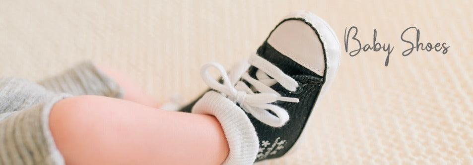 Black baby shoes with white laces and socks, perfect for tiny feet
