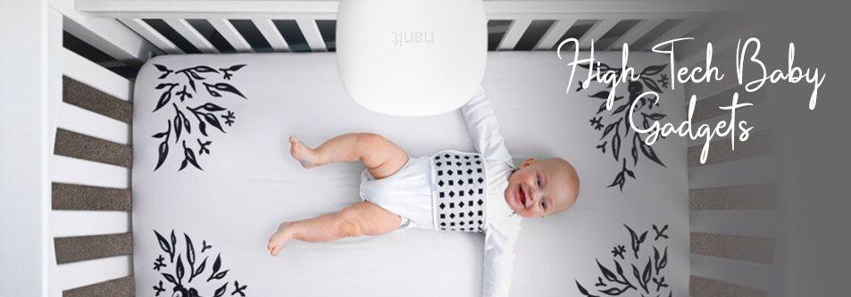 Baby in crib with high-tech monitoring gadget, floral mattress, and cozy bedding for safe sleep