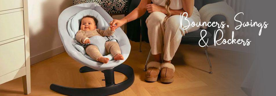 Baby in gray bouncer rocker with mom holding hand, cozy nursery setting