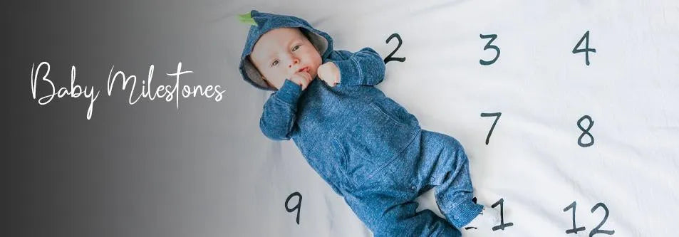 Baby in blue hooded onesie lying on milestone blanket with numbers 1-12, tracking growth and development