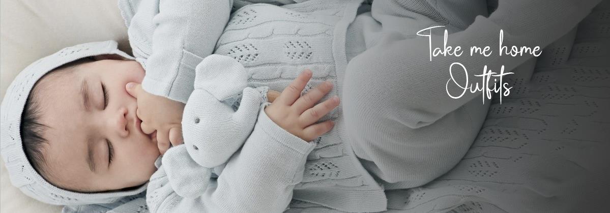 Baby in cozy knit take me home outfit with elephant plush, soft bedding