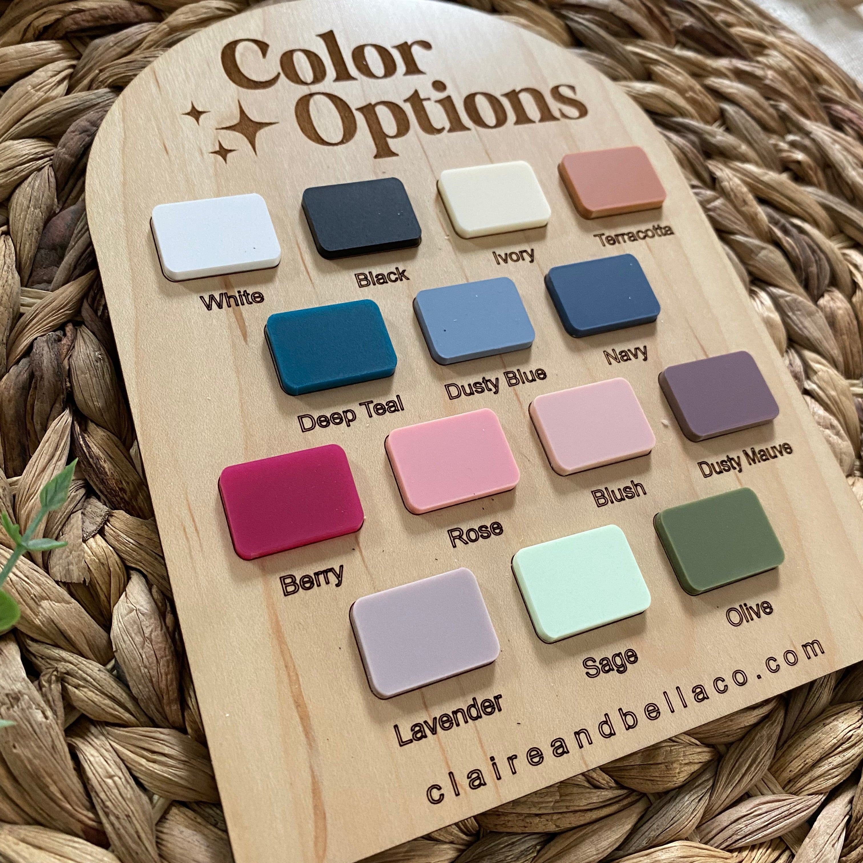 Color options swatch board with 14 pastel and neutral shades for baby products, displayed on woven mat