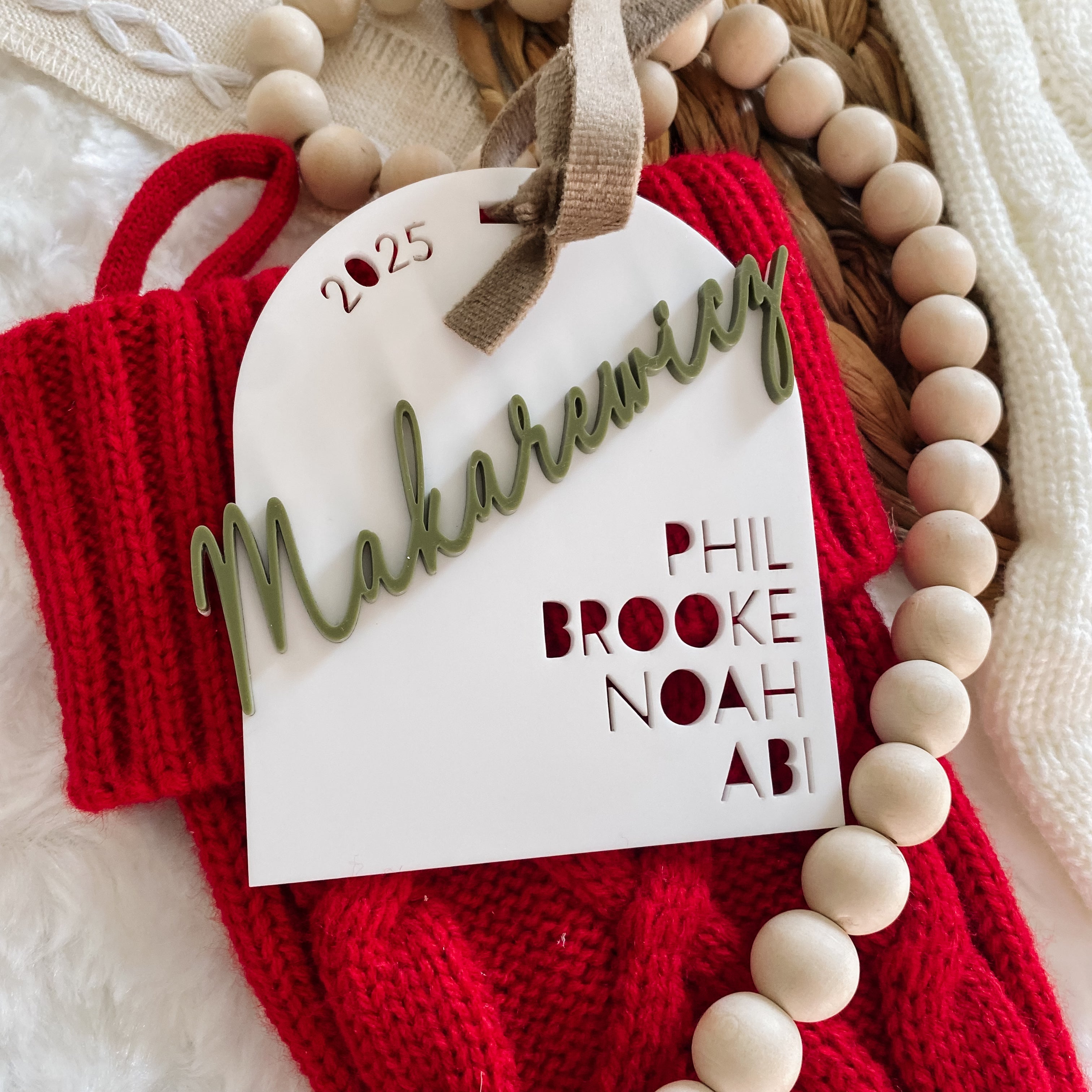 Personalized 2025 family name ornament with names Phil, Brooke, Noah, Abi on red knit background