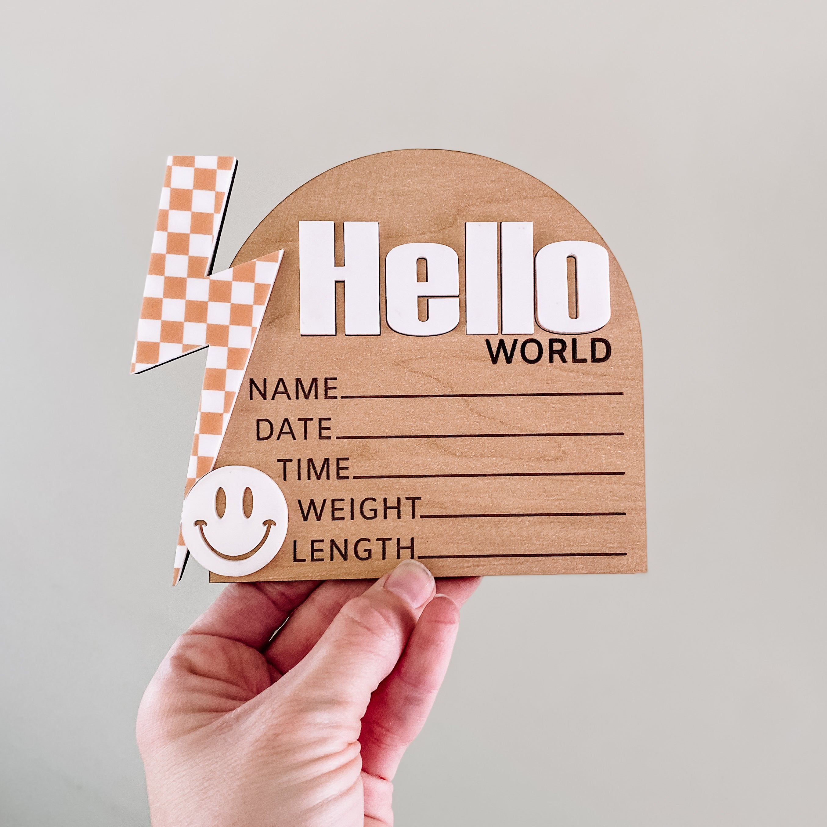 Hello World baby announcement sign with checkered flag and smiley face, perfect for newborn photoshoots