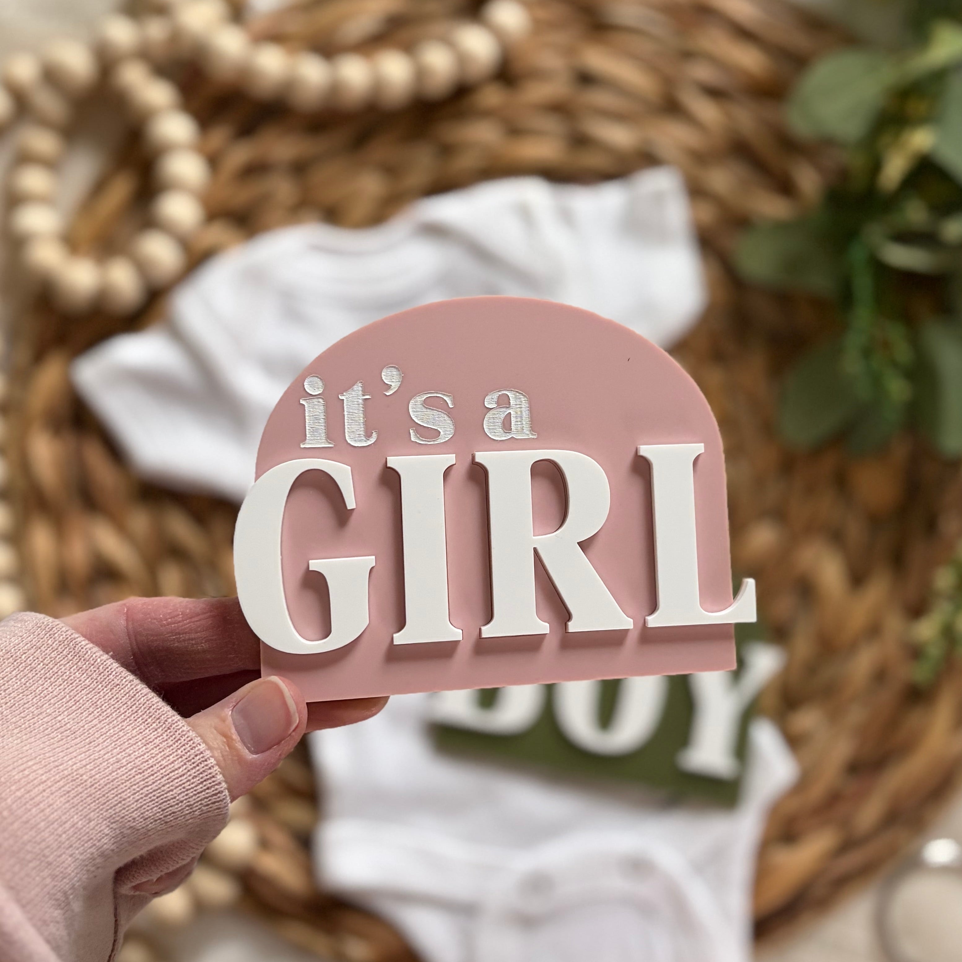 It's a Girl sign with baby onesie and wicker basket background