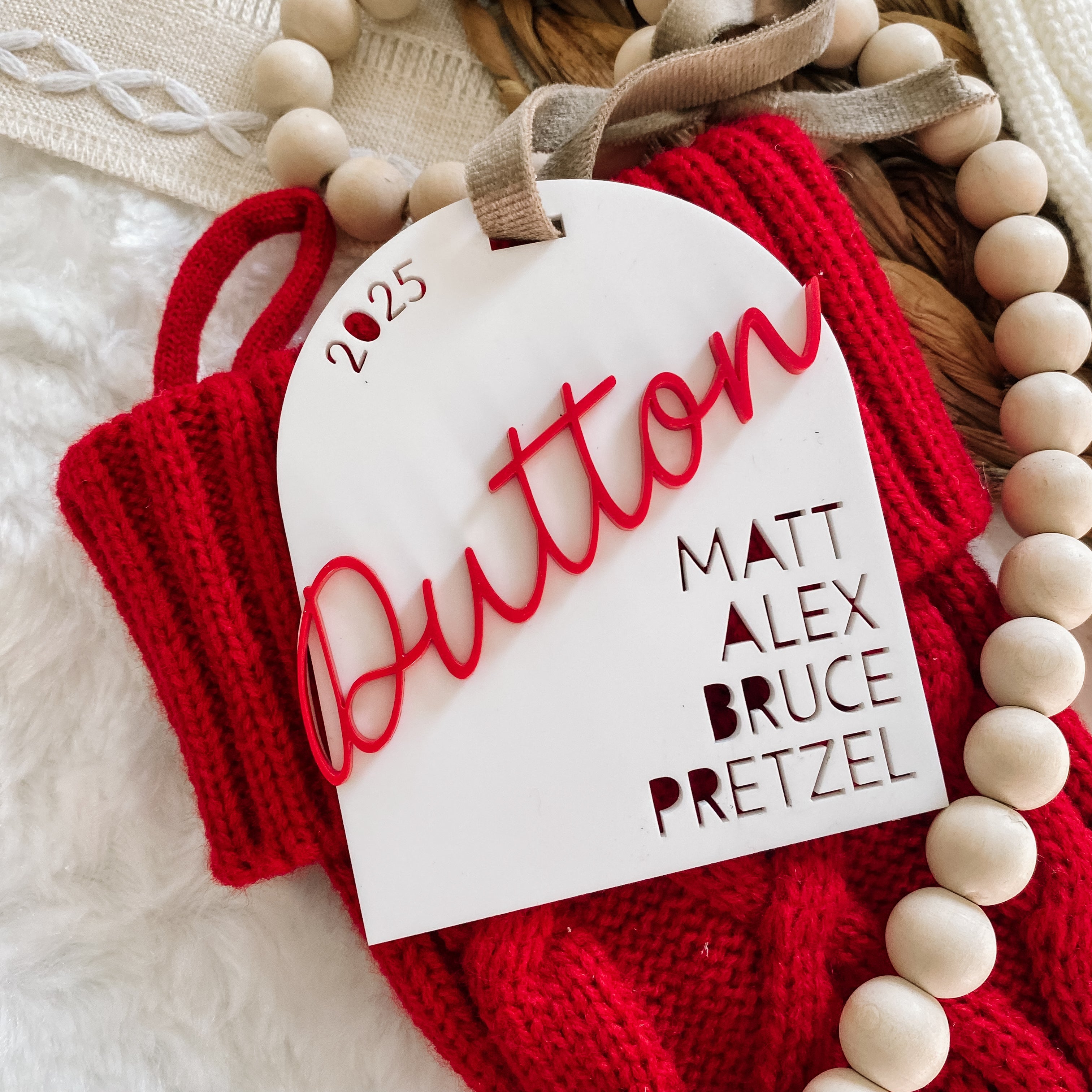 2025 Button Ornament with Names on Red Knit Background