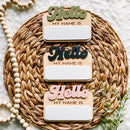 Hello My Name Is wooden signs in green, black, pink on woven mat with beads and greenery