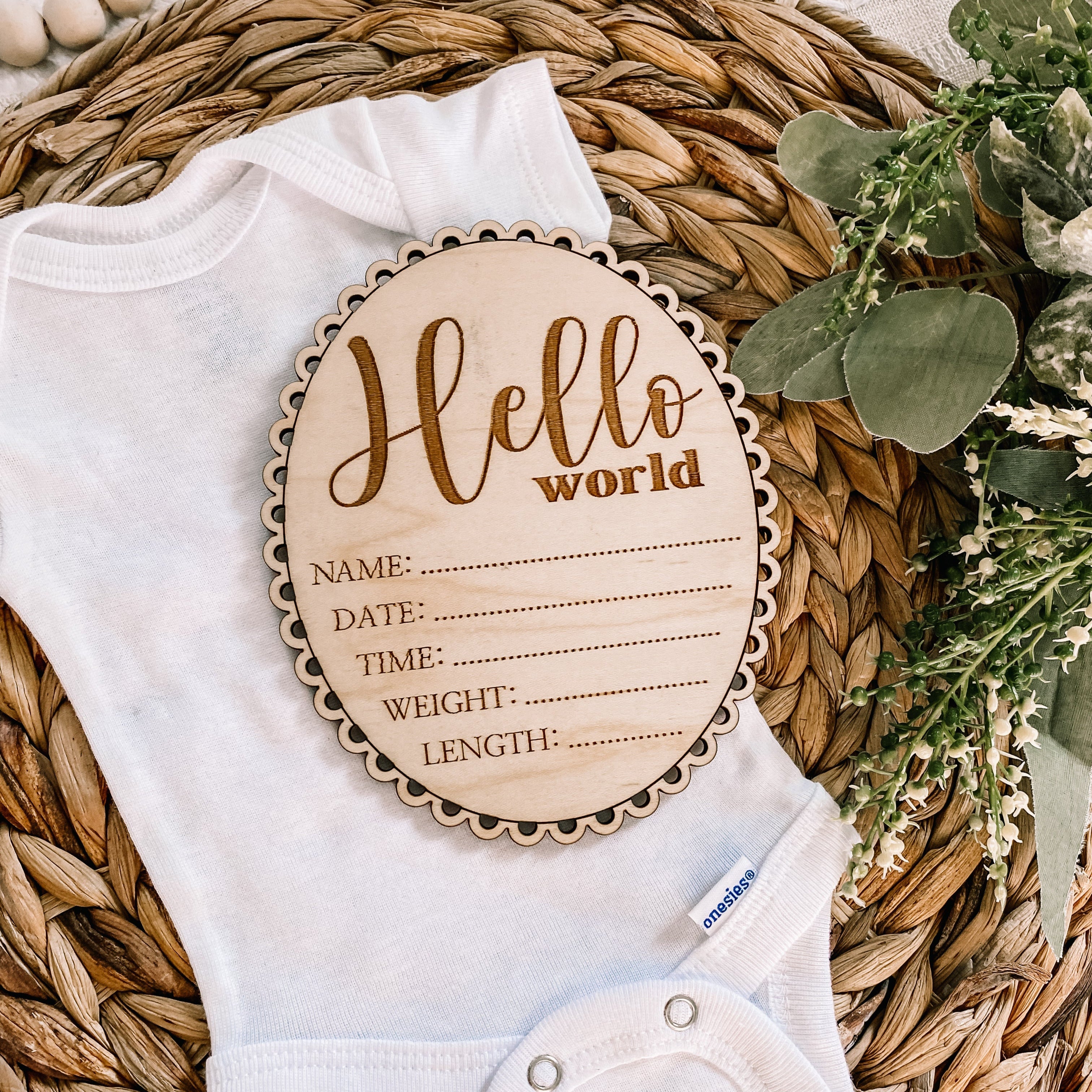 Hello World baby announcement sign on onesie with floral decor