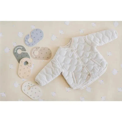 Set of 8 baby and toddler closet dividers in pastel colors, beside a white quilted jacket on a patterned background.
