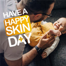 A parent and baby smiling while playing together on a couch, with text promoting healthy skin.