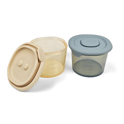 Silicone food containers by Ali + Oli in two colors, with lids and measurement markings, showcasing practical storage solutions.