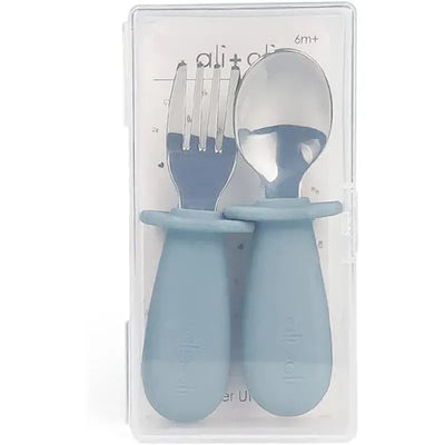 Spoon and fork learning set for toddlers in powder blue, suitable for ages 6 months and up, packaged in a clear case.