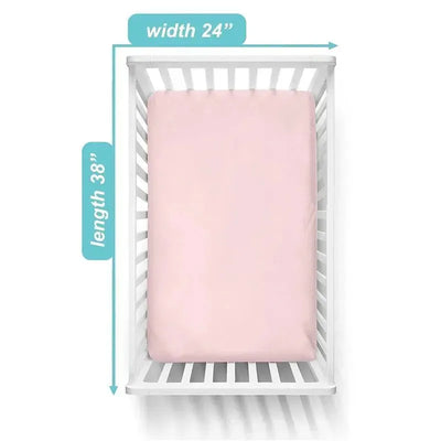 Fitted mini crib sheet in baby pink, made of 100% cotton jersey, displayed on a crib with measurements 24 x 38 inches.