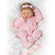 Ashton Drake Emily Baby Girl Doll, 20th Anniversary edition, dressed in a pink outfit with a matching headband, sleeping.