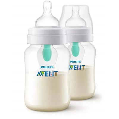 Two Avent 9oz anti-colic baby bottles with Airfree vent, filled with white liquid, featuring a blue nipple and Philips branding.
